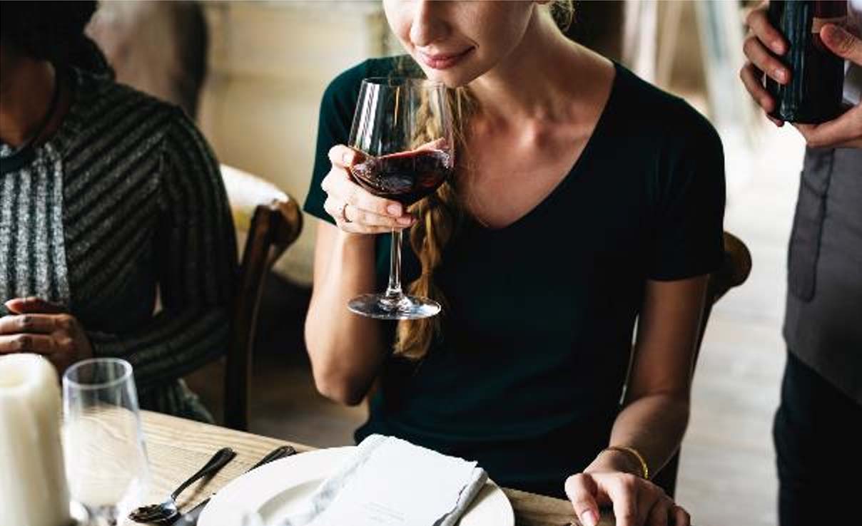 Woman Tasting Red Wine in a Classy Restaurant 